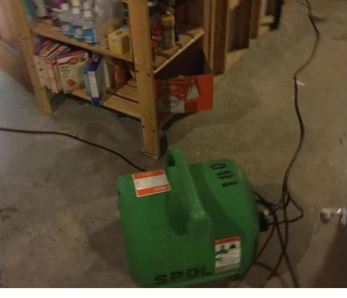 water damage being mitigated with a green SERVPRO dehumidifier 