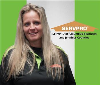 Blonde haired woman smiling with green and black background and a SERVPRO logo