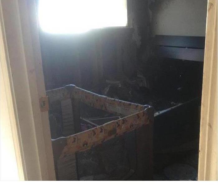 fire damaged room with playpen in it 