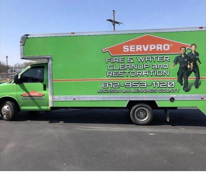 a green SERVPRO truck outside on a sunny day 