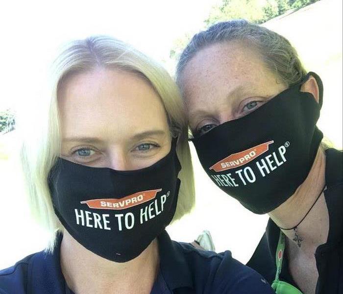 Two people in masks staring at the camera at a golf event. 
